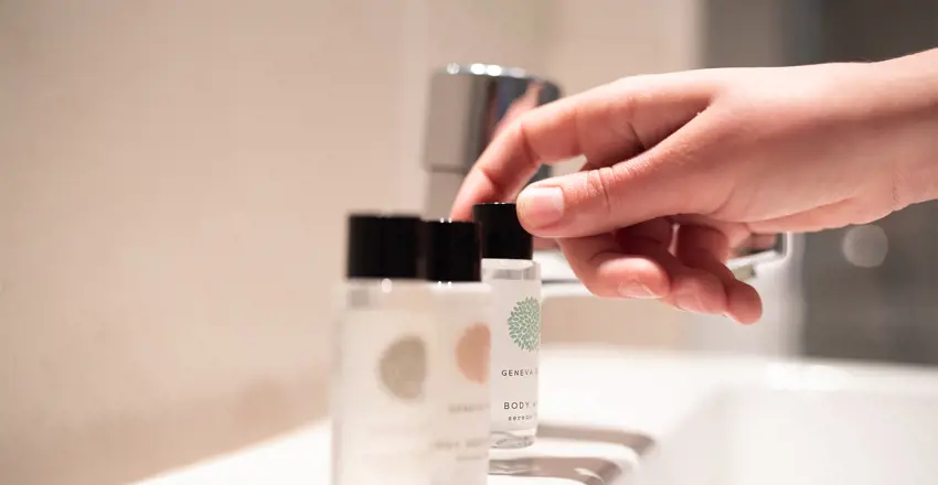 Hand reaching for toiletry minitures